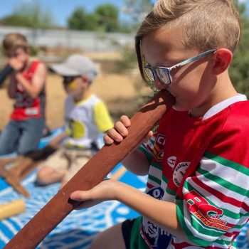 local boy playing didgeridoo at Ashmont Re-Opening Event